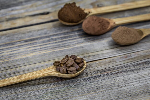 Маленькие деревянные ложки с кофейными зернами и кофейным порошком
