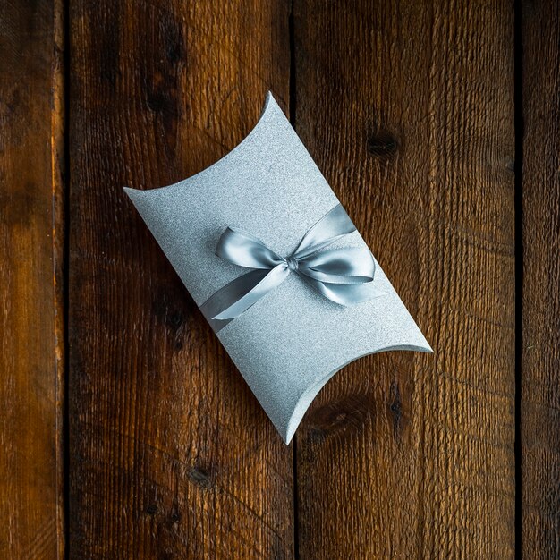 Little wrapped gift on wooden background