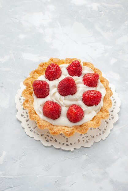 little yummy cake with cream and fresh red strawberries on light desk, cake fruit biscuit sweet cream