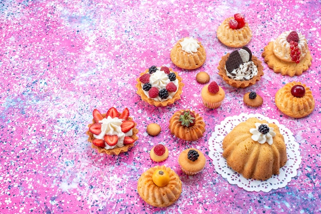 Free photo little yummy cakes with cream along with different berries on light,  cake biscuit berry sweet bake tea