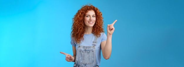 Free photo lively joyful goodlooking s redhead curlyhaired sassy girl summer positive mood dancing overalls poi