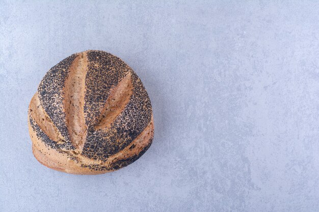 Loaf of black sesame coated bread on marble surface