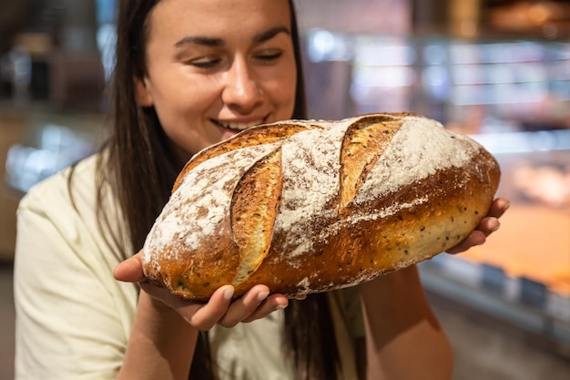 Free photo loaf of bread in female hands in a supermarket