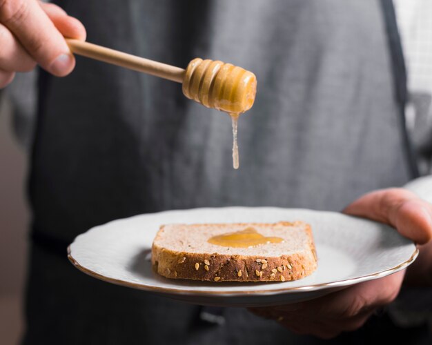 Loaf of bread with honey on plate