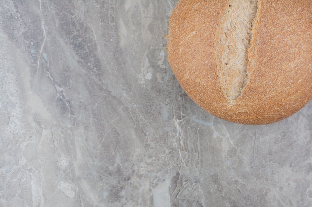 Loaf of fresh bread on marble surface