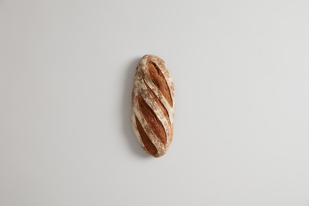 Loaf of long white bread made on leaven and organic flour, isolated. Homemade baking concept. Healthy nutrition. Carbohydrate product. Eating and consumerism. Overhead view. Selective focus.
