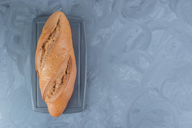 Бесплатное фото Буханка ржаного хлеба на мраморном столе.