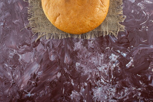 Буханка круглого хлеба с корочкой на вретище.