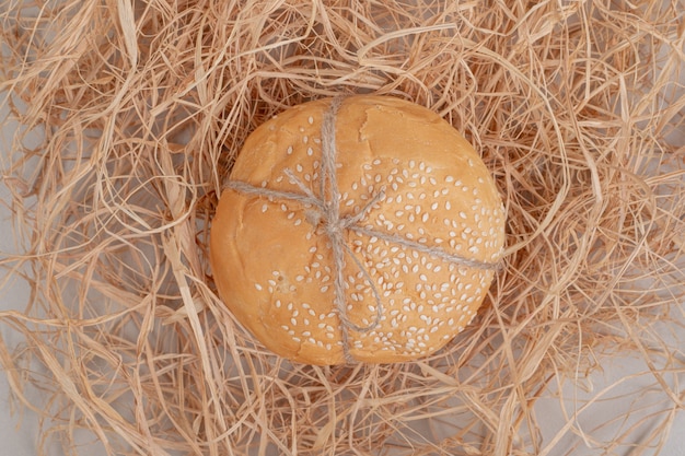 Loaf of small burger bread in rope on white surface