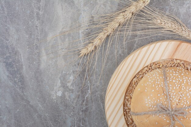 Una pagnotta di pane bianco con chicchi di avena su tavola di legno