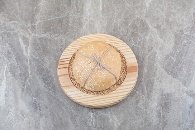 Free photo a loaf of white bread with oat grain on wooden board