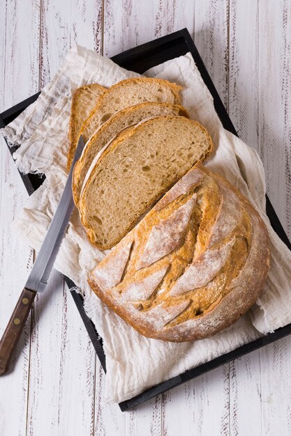 Loaves of bread with knife on baking tray