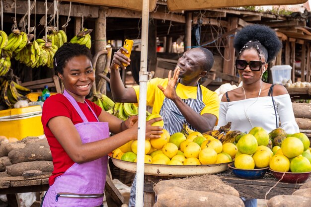 Local market scene with happy traders selling, one using his phone to make video call