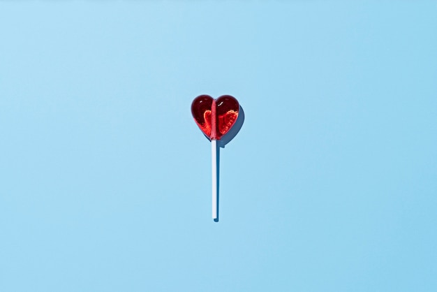 Lollipop heart on blue background top view
