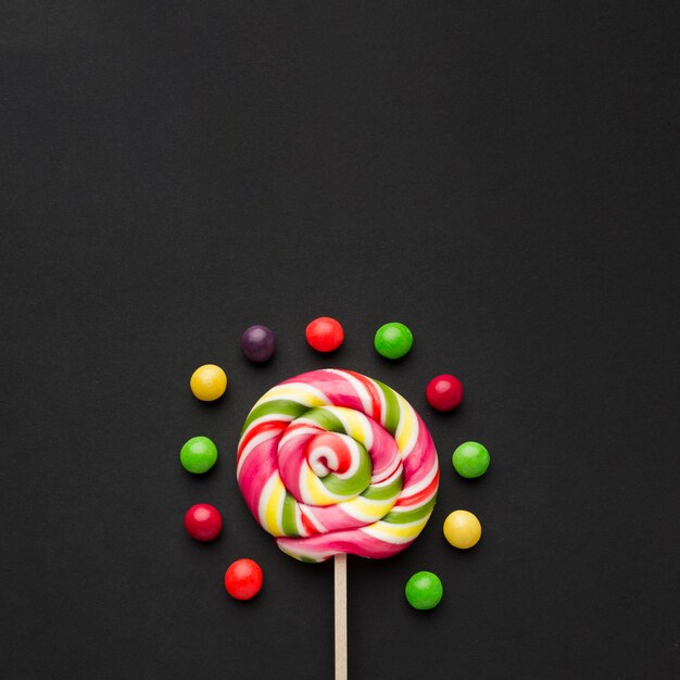 Lollipop and sweets on black table