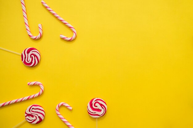 Lollipops and candy canes on yellow background
