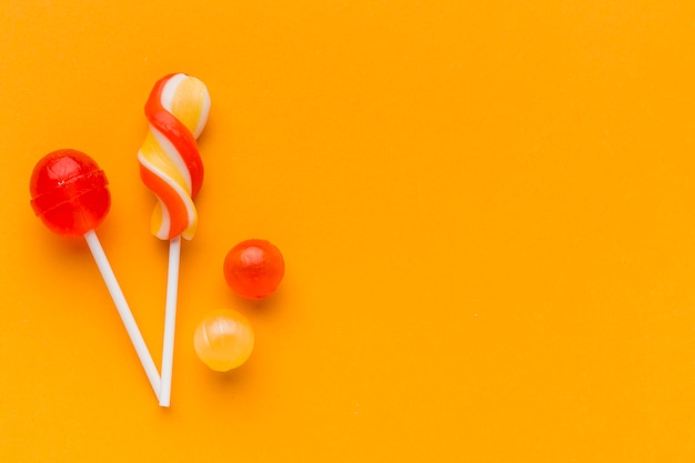 Lollipops on orange table with copy space