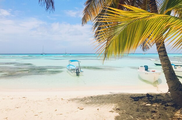 Lonely boats on turquoise water before golden beach