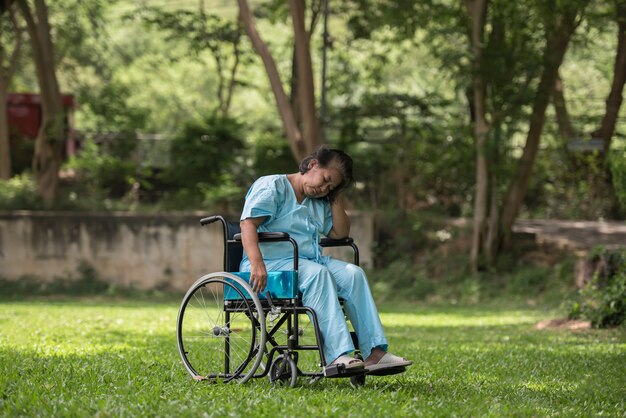 병원 정원에서 휠체어에 슬픈 느낌을 앉아 외로운 노인 여성