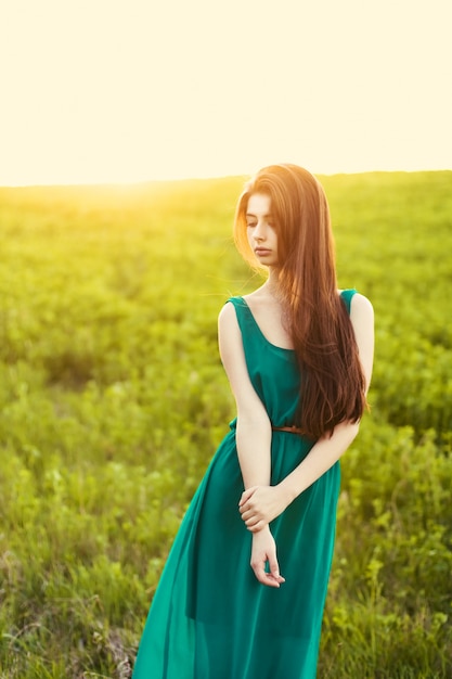 Lonely girl on the meadow at sunset