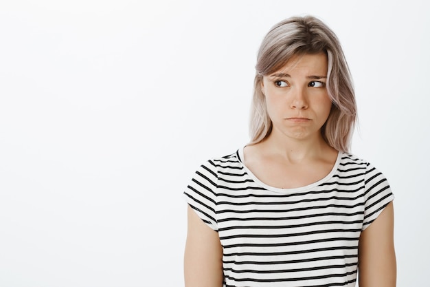 Free photo lonely gloomy blonde girl posing in the studio