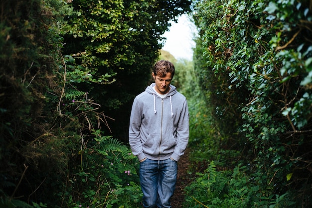 Free photo lonely person walking along a pathway with beautiful greenery