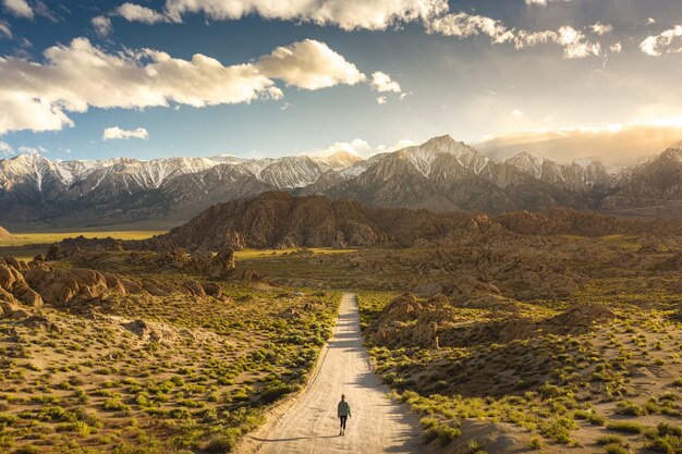 Lonely person walking on a pathway in Alabama hills in California with Mount Whitney