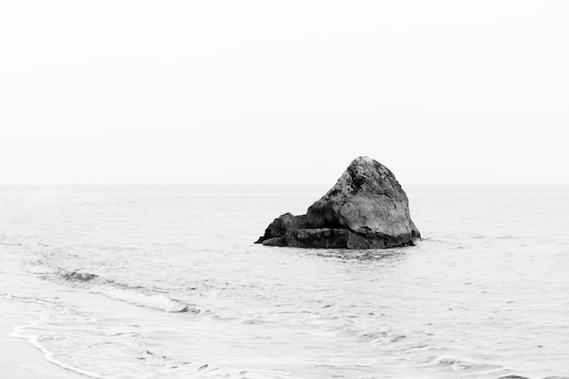 孤独な岩。最小限のモノクロの海景