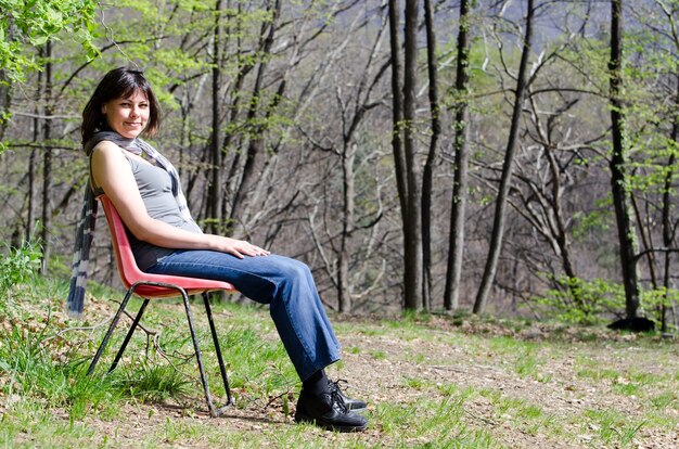 Lonely woman sitting on a chair and relaxing in a park