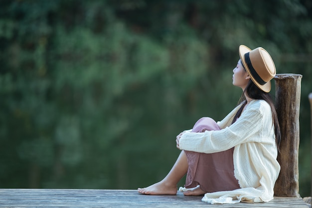 Free photo lonely woman sitting on the waterfront raft