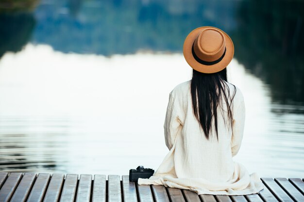 Lonely woman sitting on the waterfront raft