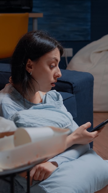 Lonely woman with anxiety and mental problems browsing on smartphone