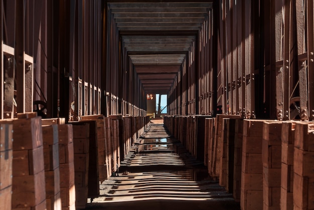 Long corridor in the industrial building with shadows of the columns on the ground