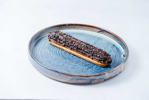 Long eclair topped with chocolate and chips