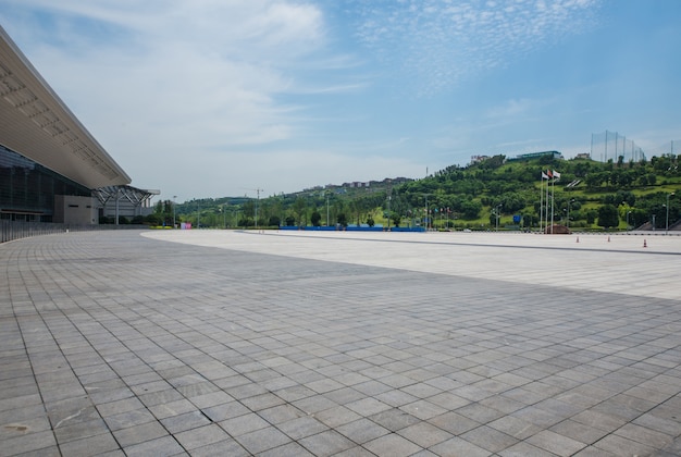 long empty footpath in modern city square with skyline