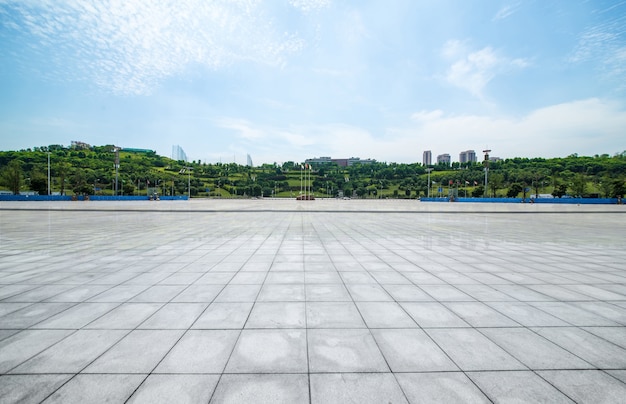 long empty footpath in modern city square with skyline