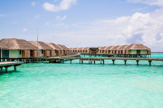 Long empty jetty in the Maldives with coral reefs in the water