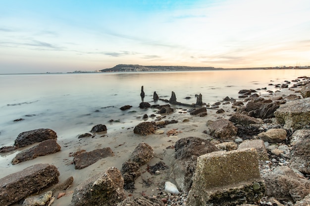 Long exposure shot of the stones on the shore near Portland, Weymouth, Dorset, UK