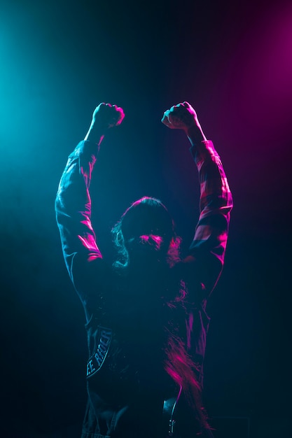 Long hair artist holding hands in the air on stage