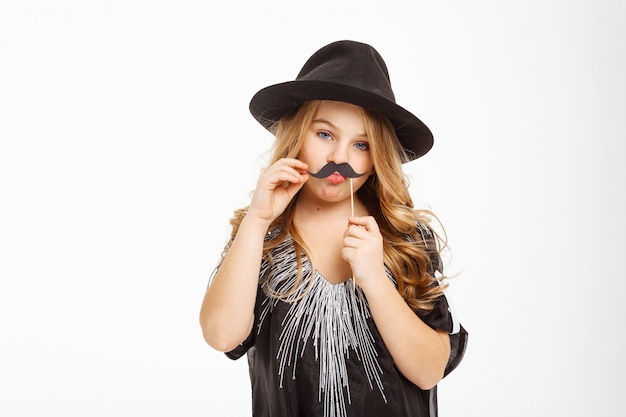 Long haired blonde posing with moustache mask on a stick.