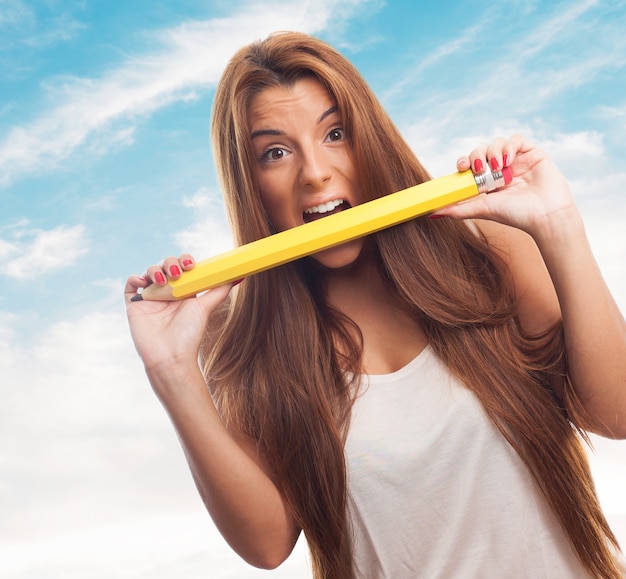 Foto gratuita femminile dai capelli lunghi scricchiolio grande matita.