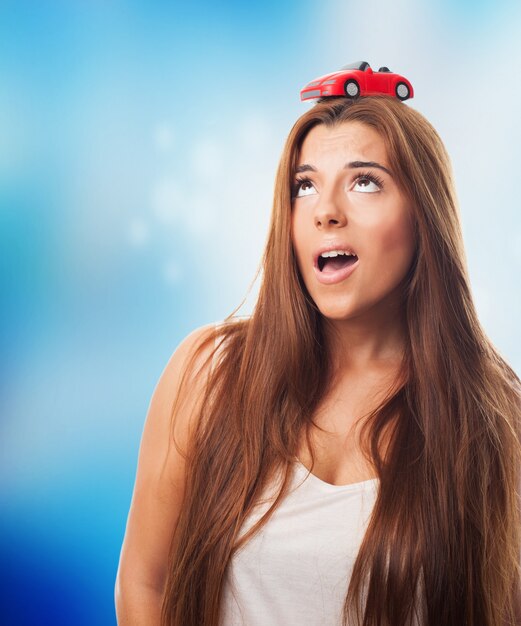 Long-haired female with a small red car on her head