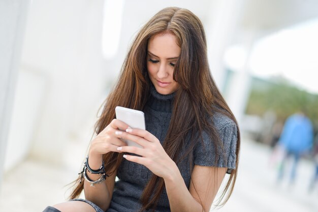 彼女の携帯電話でテキストメッセージ長い髪の少女