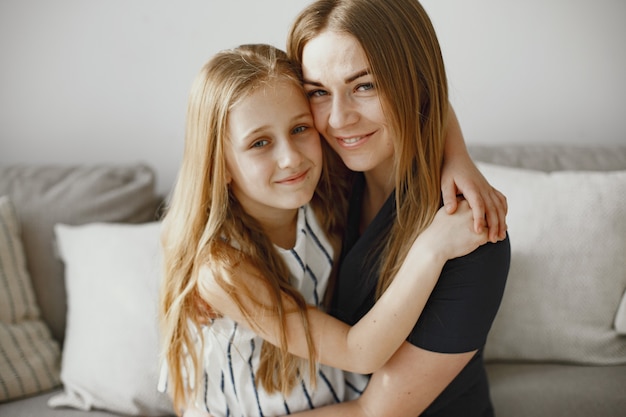 Long haired girls. Happy mom with daughter. Daughter hugging mom