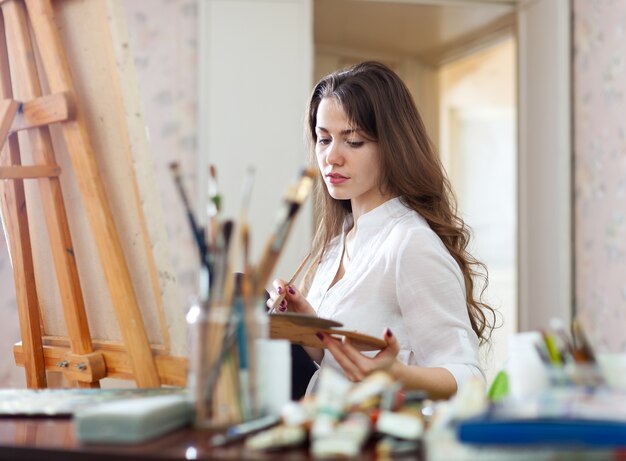 Long-haired woman   paints on canvas