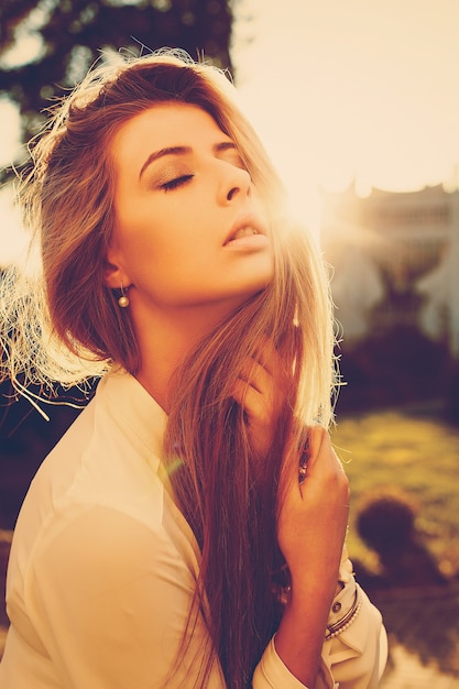 Free photo long-haired young woman enjoying the sunset outdoors