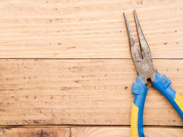 Long pliers on wooden table