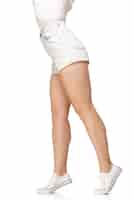 Foto gratuita gambe lunghe e graziose della donna isolate sulla parete bianca con copyspace. pronto per il tuo design. figura sportiva e in forma, concetto di moda e bellezza.