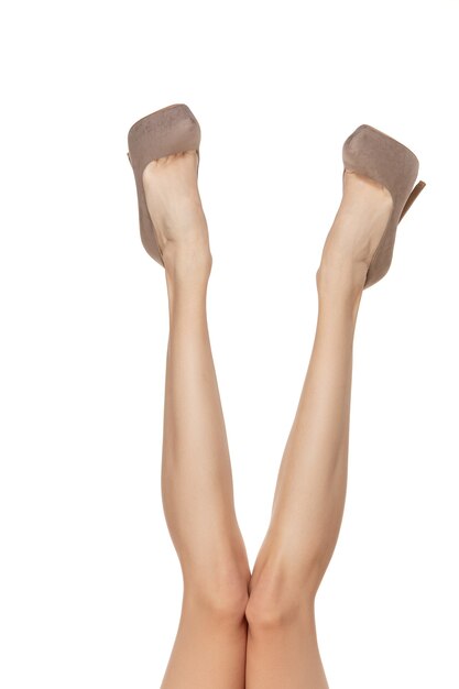 Free photo long pretty woman legs isolated on white wall with copyspace. ready for your design. sportive and fit figure, fashion and beauty concept.