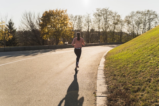 Long shot active woman running in the park